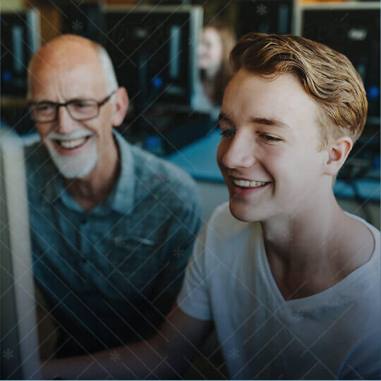 Student smiling on computer with teacher