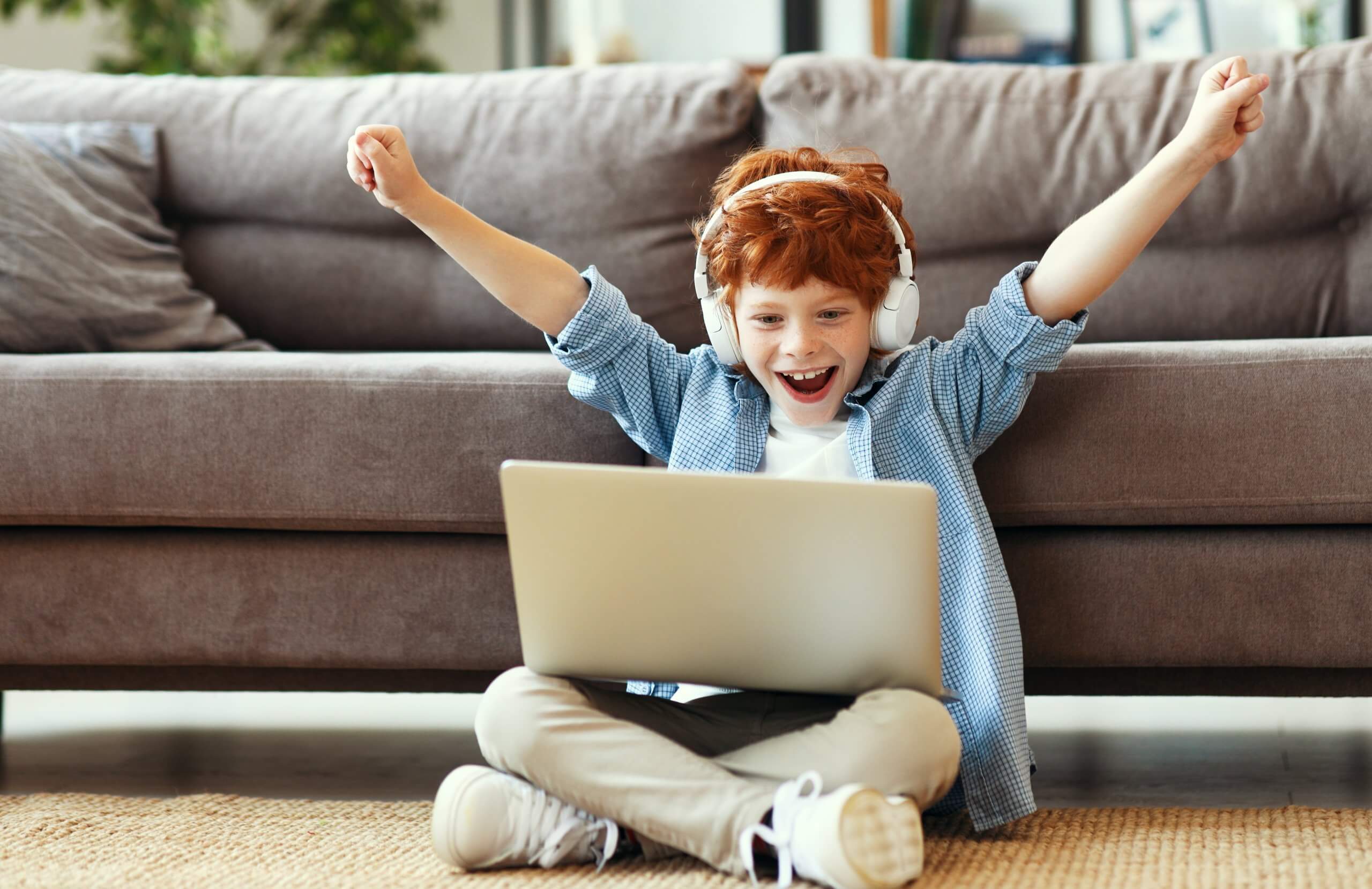 Excited elementary student in coding class sitting at computer