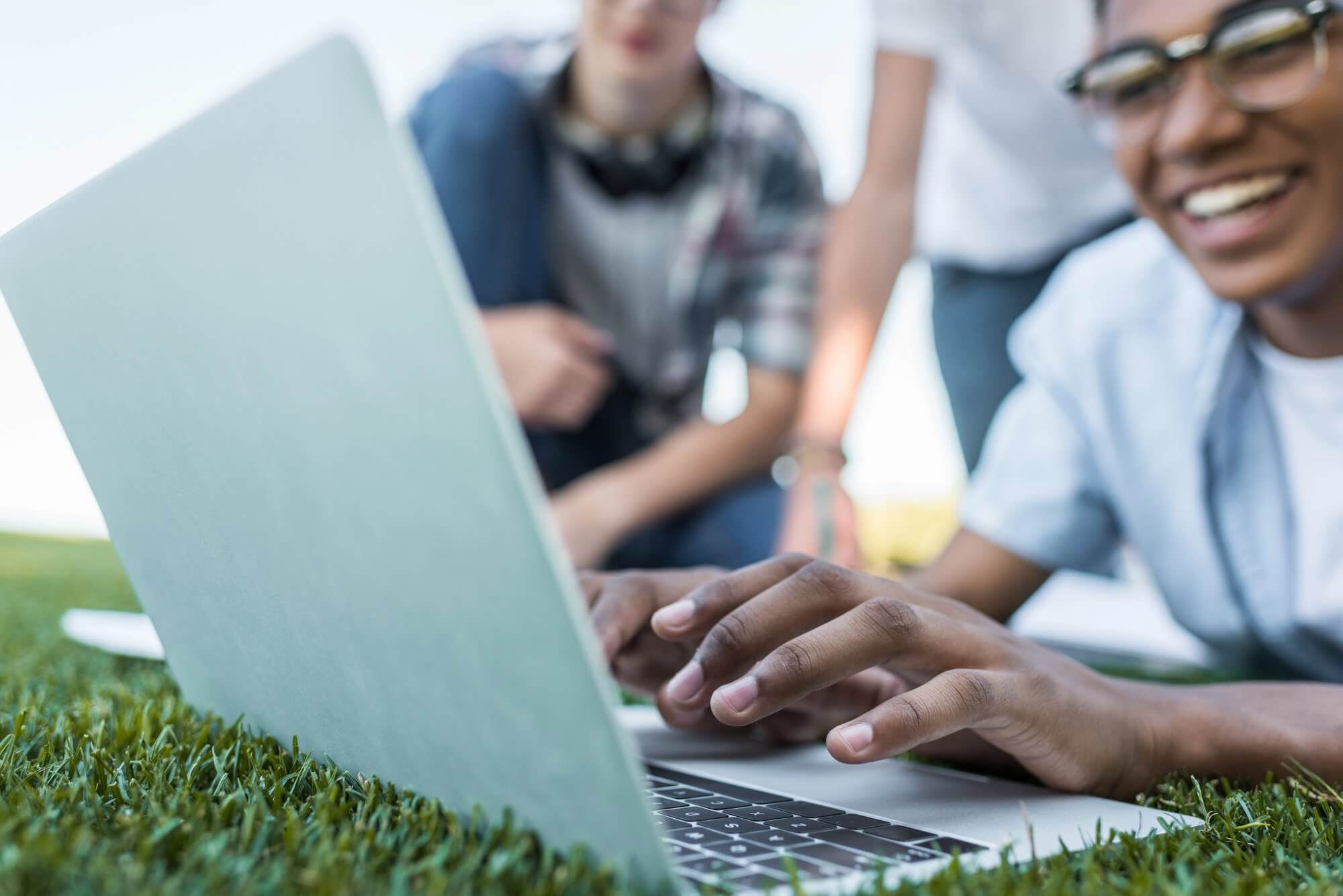 Teen boys outside on computer coding